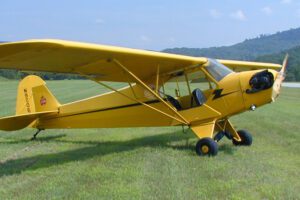 Flight academy's J3 Cub sits in the grass just off the runway at Van Nuys Airport