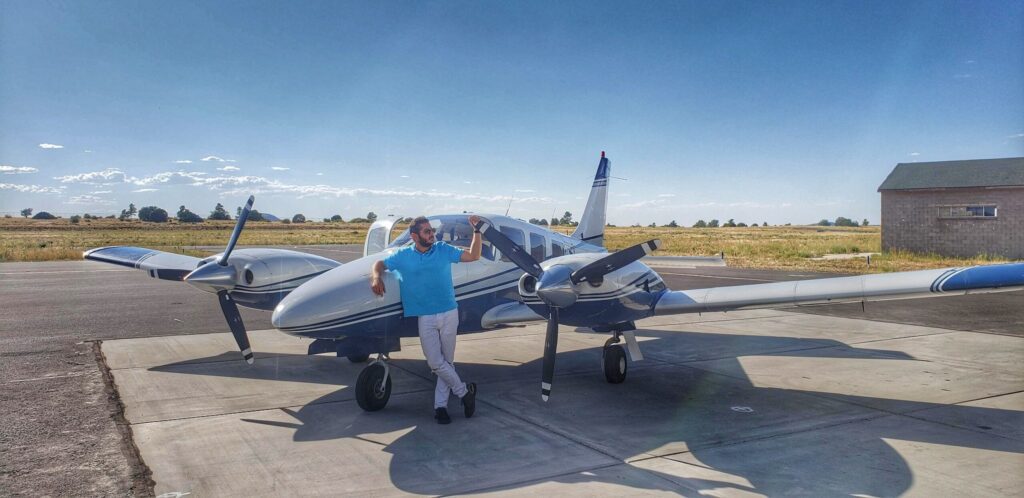 Flight instructor poses with twin engine plane before Multi-Engine Flight Training