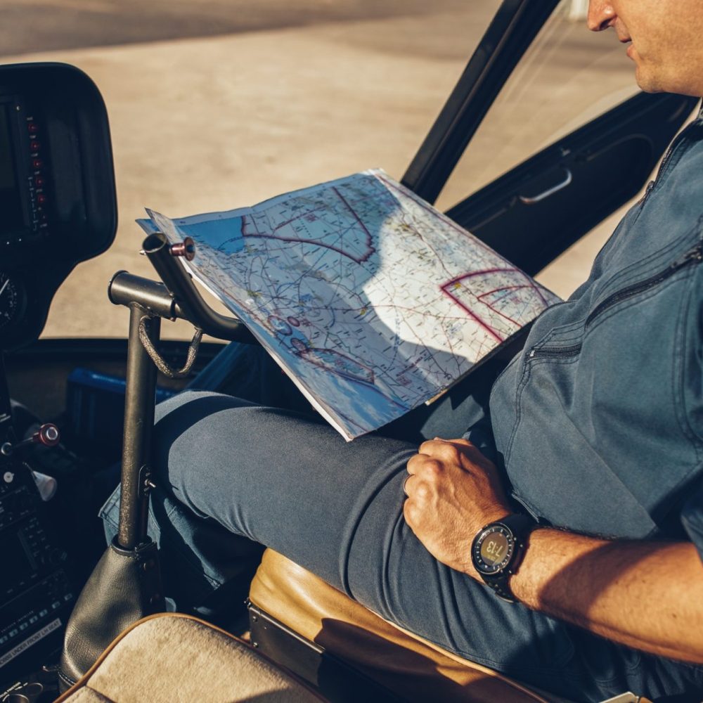 Pilot checking aeronautical chart while in cockpit.