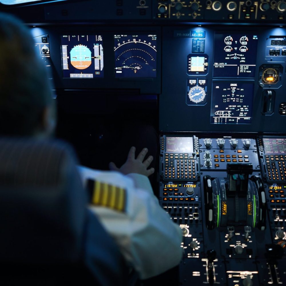 Inside of commerical cockpit with all glass instruments overlooking pilots shoulder.